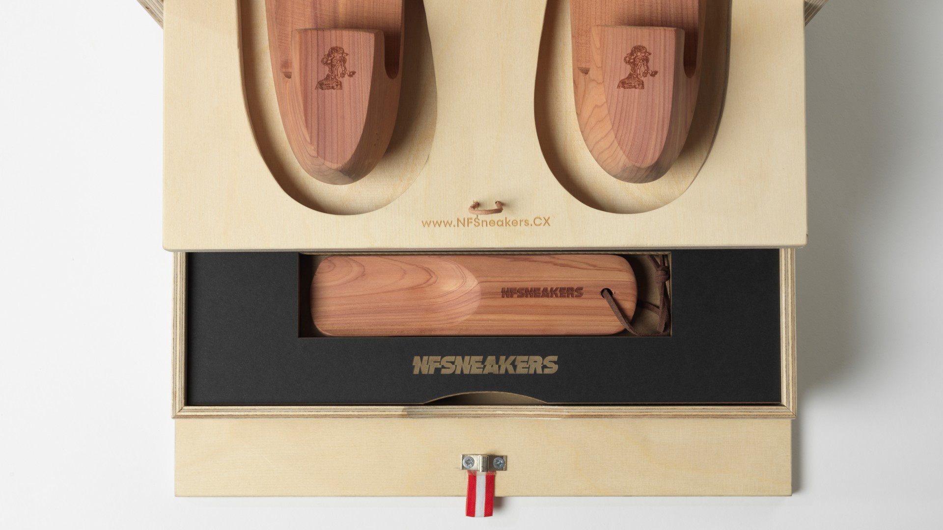 Detailansicht vom Innenleben der Schuhbox. Gravuren auf der Schachtel und dem Schuhlöffel